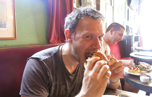 Daniel tucking into a delicious burger too big for his mouth