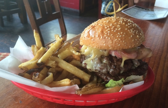 A picture of the Bronx burger, served up with fries.   
