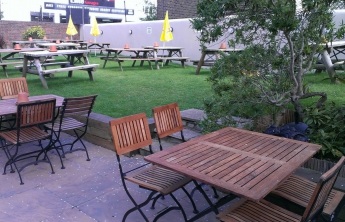 The outside seating area with wooden chairs and tables where we ate