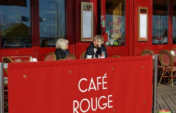 Two women chatting outside the Cafe Rouge