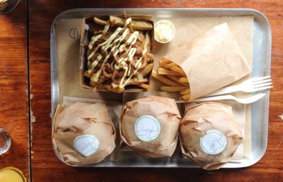 The food served in a metal tray with plastic forks